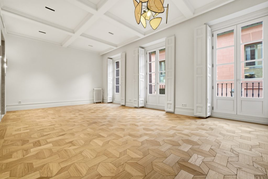 Salón reformado con diseño atemporal, techos altos y grandes ventanales.