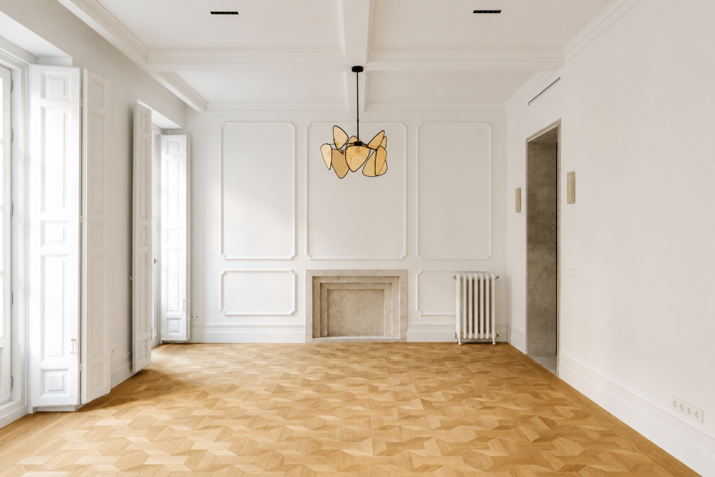 Interior de vivienda reformada con diseño atemporal, chimenea y luz natural.