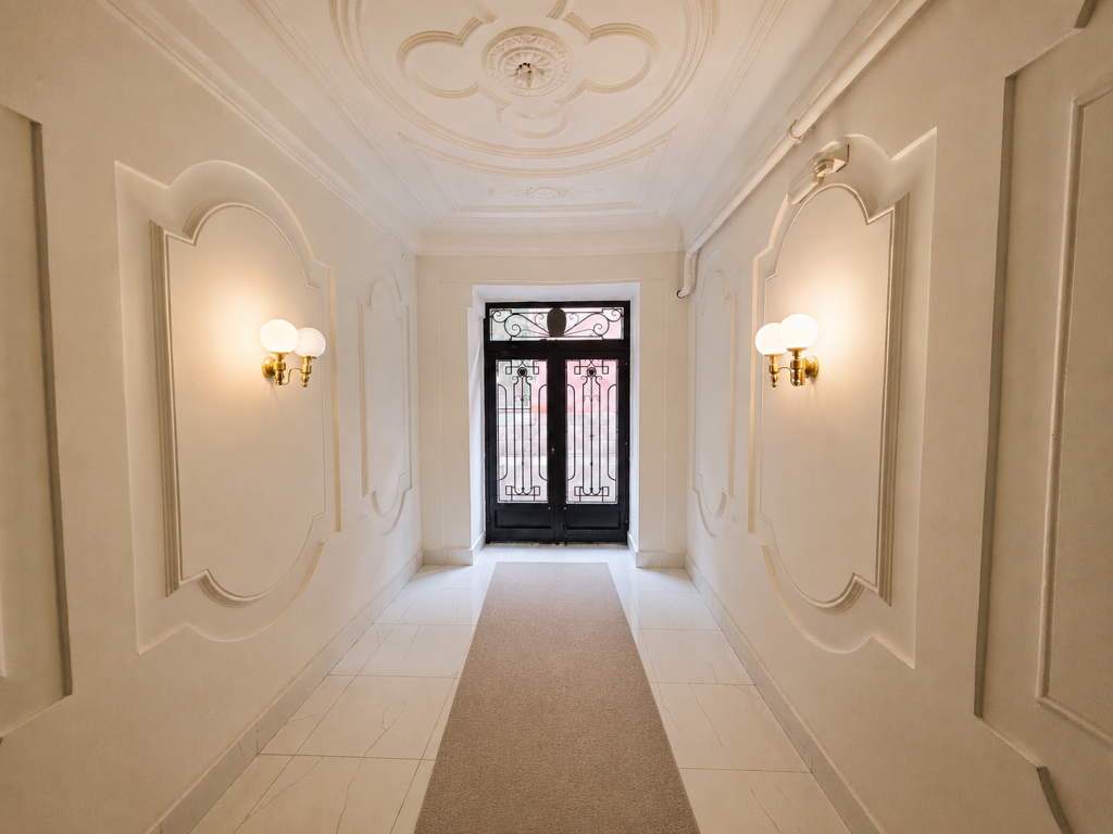 Portal de edificio residencial rehabilitado con acabados cuidados, un elemento que mejora la percepción de calidad del inmueble.